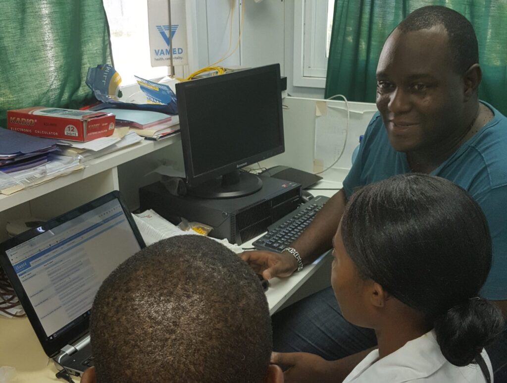 Three people working in an office on the implementation of an OpenHIE leveraging IPS